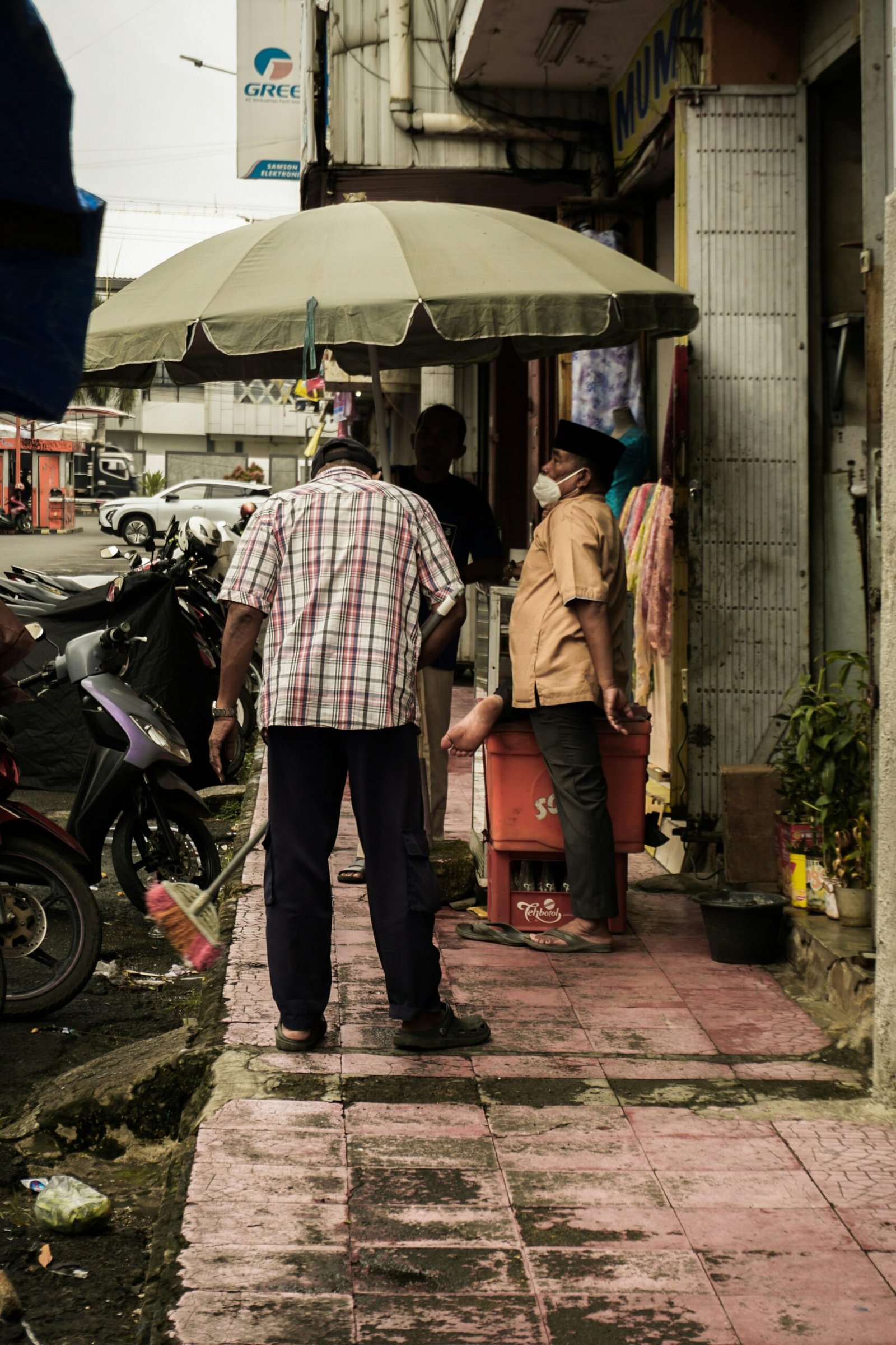 A man standing on a sidewalk next to a motorcycle