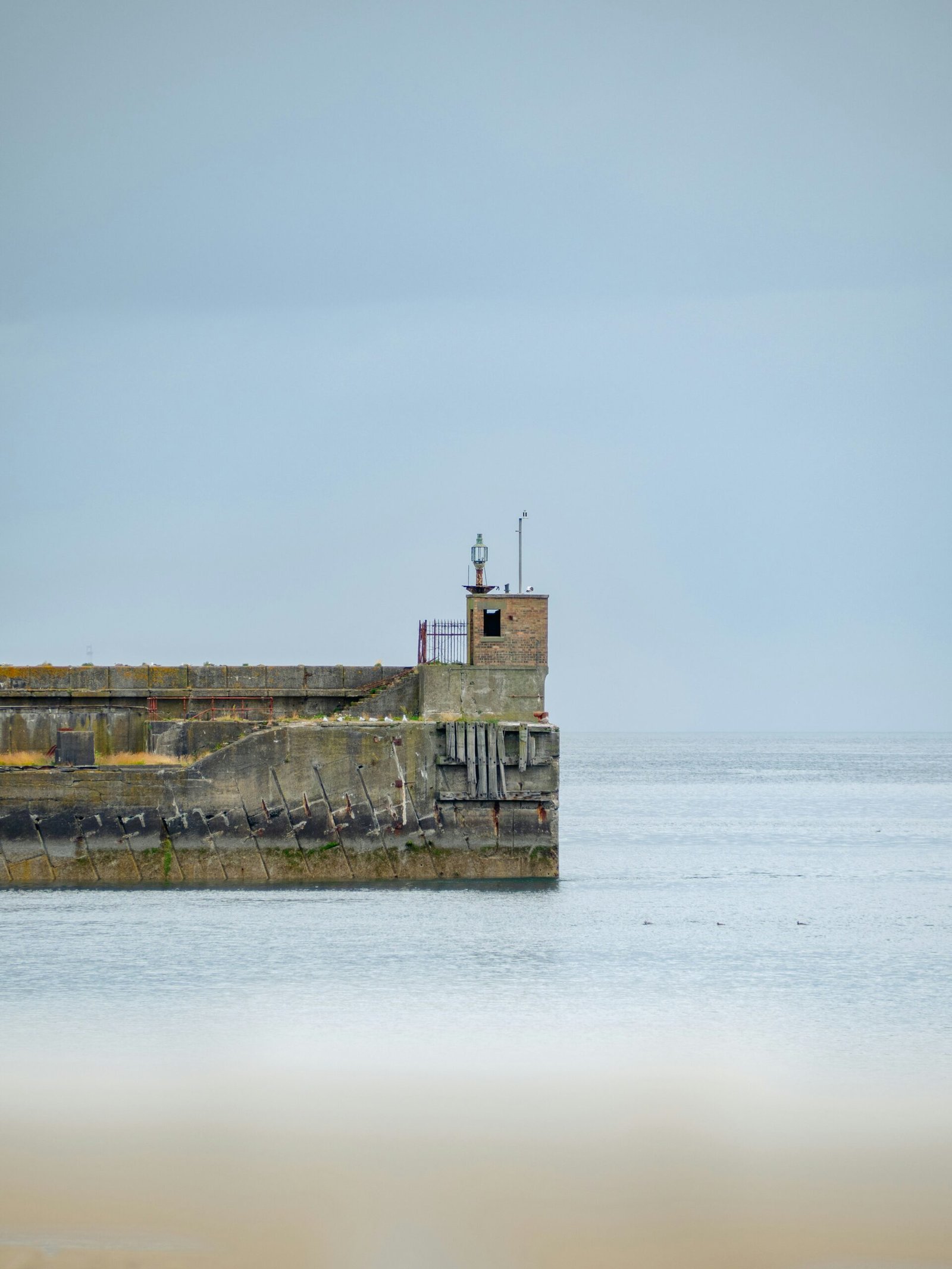 A lighthouse on a small island in the middle of the ocean